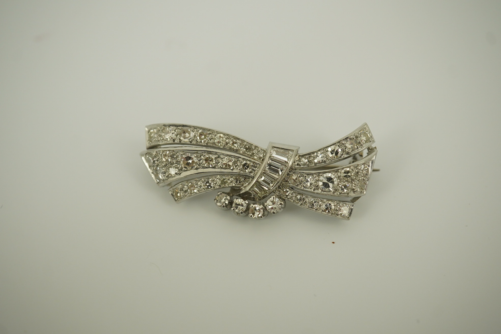 A mid 20th century platinum? and diamond cluster scroll brooch